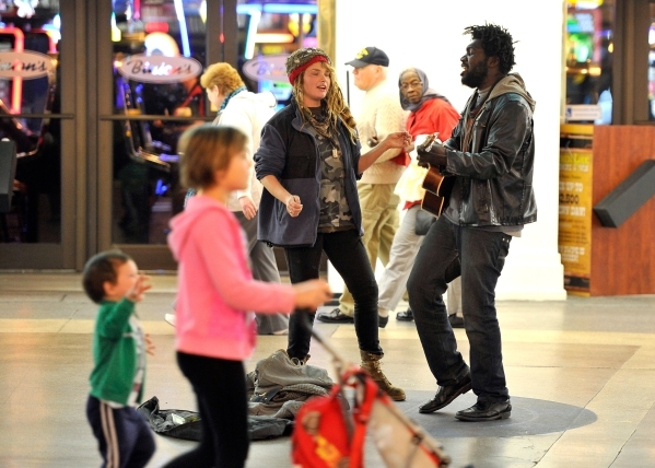 Raskull Jackson, center, and her boyfriend, Master Ghost Jackson, right, perform as people walk by at the Fremont Street Experience Monday, Jan. 11, 2016, in Las Vegas. Buskers and street performe ...