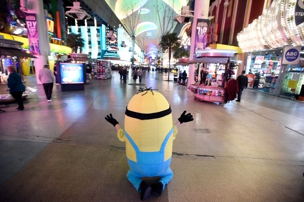 A Minion character encourages people to pose for pictures at the Fremont Street Experience Monday, Jan. 11, 2016, in Las Vegas. Buskers such as these characters are required to register before per ...