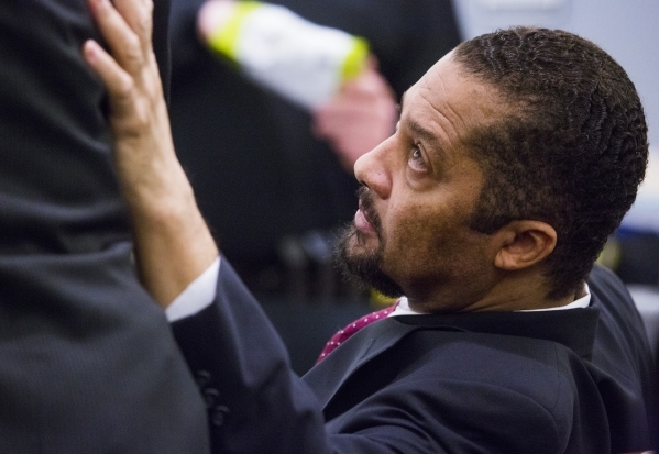 Otis Holland, a former pastor accused of sexually assaulting young girls, touches his attorney before testifying in his own defense at Regional Justice Center, 200 Lewis Ave., in Las Vegas on Wedn ...