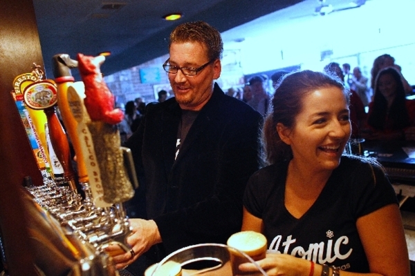Owner Derek Stonebarger, left, and bartender Ashlea Latham pour beers during the opening of Atomic Liquors in June 2013 in downtown Las Vegas.