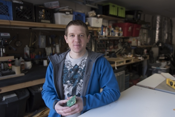 Kyle Kimsey poses with a Raspberry Pi 2 chip that he plans to desolder and install into one of his drones in his workspace at his Las Vegas home Thursday, Jan. 14, 2016. Kimsey is the winner of th ...