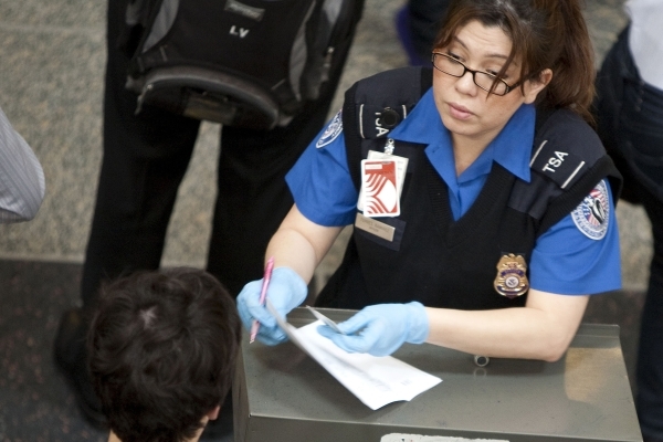 A Transportation Security Administration employee checks the identification of passengers before they enter security screening at Reagan National Airport in Washington on May 2, 2011. (Joshua Robe ...