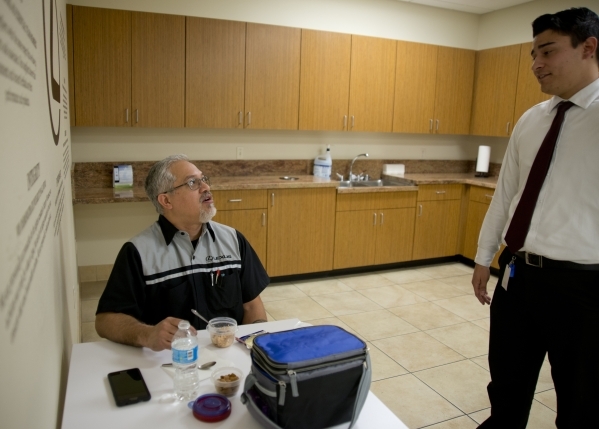 Kenny Kamae, a service technician at Lexus of Henderson in the Valley Automall, left, speaks with Gerrit Cuellar while eating a lunch he carefully portioned and selected to help control his high b ...