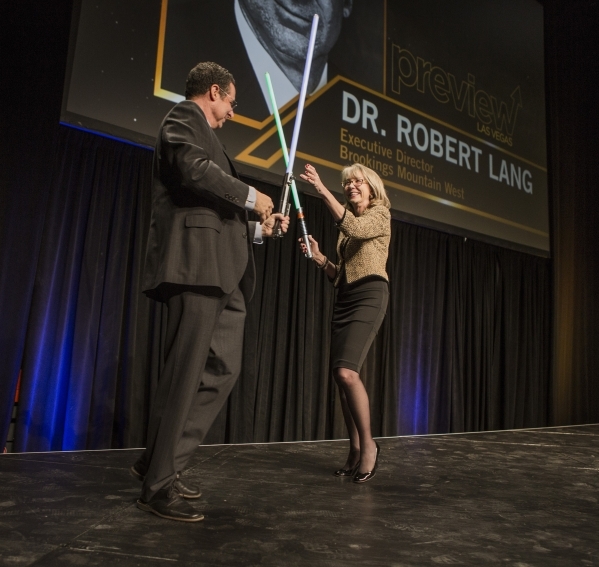 Dr. Rob Lang, left, executive director, Brookings West, and Kristin McMillan, president and CEO of the Las Vegas Metro Chamber duels with sabers during Preview at the Cox Pavilion on the UNLV Camp ...