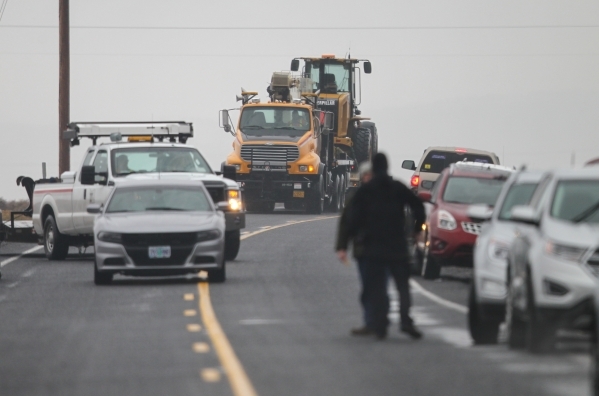 Heavy equipment is led by an unmarked Oregon State Police vehicle outside of the Malheur National Wildlife Refuge, where four anti-government protesters remain, about 30 miles south of Burns, Ore. ...