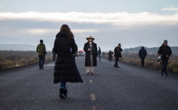 Becky Hudson of Eagle, Idaho, looks on as news media members walk around near a police roadblock just outside of the Malheur National Wildlife Refuge headquarters, where four anti-government prote ...