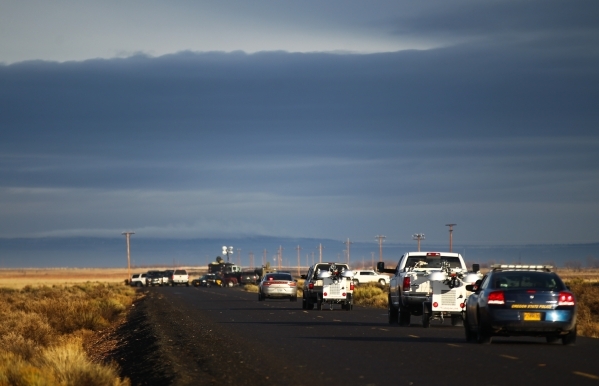 Police vehicles drive toward a roadblock just outside of the Malheur National Wildlife Refuge headquarters, where four anti-government protesters remain, about 30 miles south of Burns, Ore., on Th ...