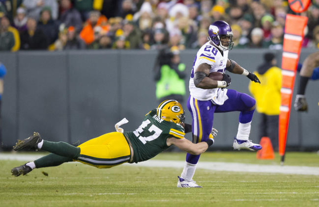 Jan 3, 2016; Green Bay, WI, USA; Minnesota Vikings running back Adrian Peterson (28) rushes with the football as Green Bay Packers linebacker Jake Ryan (47) defends during the second quarter at La ...