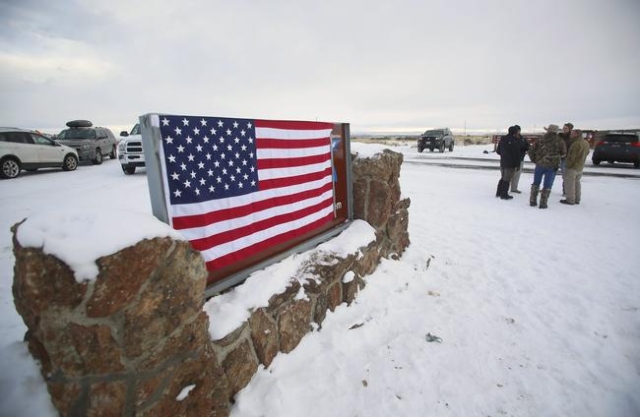 A U.S. flag covers a sign at the entrance of the Malheur National Wildlife Refuge near Burns, Oregon January 3, 2016. REUTERS/Jim Urquhart