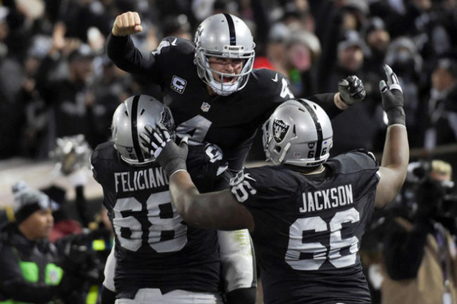 Dec 24, 2015; Oakland, CA, USA; Oakland Raiders quarterback Derek Carr (4) celebrates with offensive guard Jon Feliciano (68) and guard Gabe Jackson (66) after a touchdown in the fourth quarter ag ...