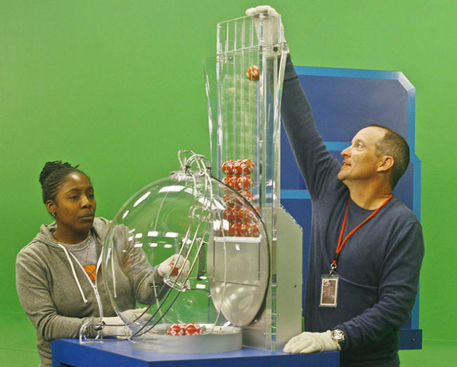 Draw Managers Robert Bechtol (R) and Tiffany Hicks (L) load Powerball numbers before the drawing at the Florida Lottery studio in Tallahassee, Florida January 13, 2016. They are using gloves to pr ...