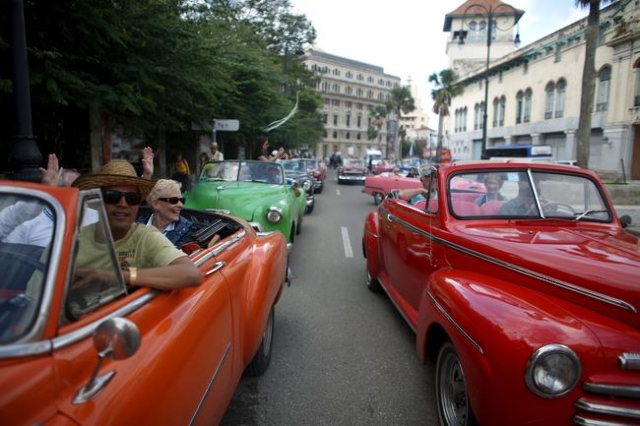 Tourists enjoy a ride in vintage cars in old Havana in this January 17, 2016 picture. REUTERS/Alexandre Meneghini