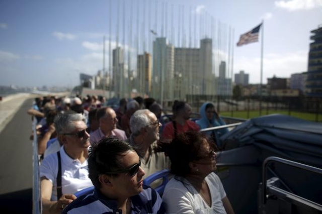 Tourists look at the U.S. Embassy from the top of a double decker sightseeing bus in Havana, in this January 17, 2016 picture. REUTERS/Alexandre Meneghini
