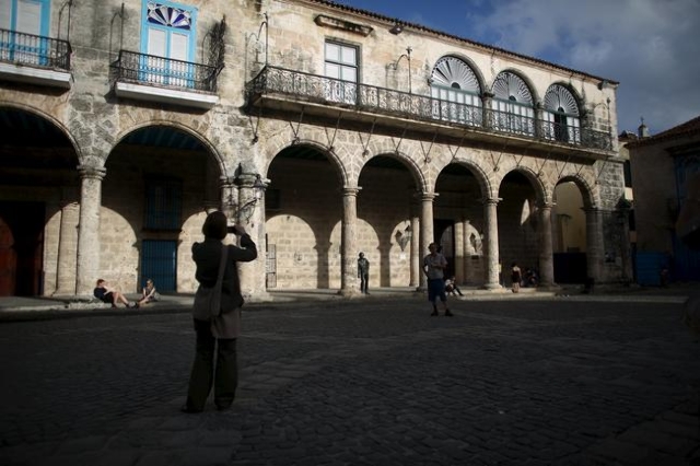 A tourist takes pictures at the Cathedral Square in old Havana in this January 17, 2016 picture. REUTERS/Alexandre Meneghini
