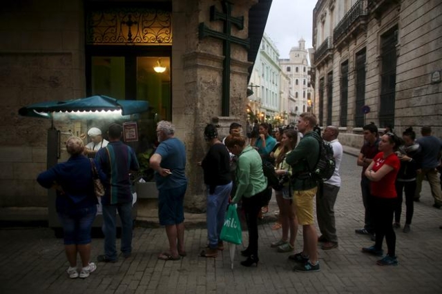 Tourists and Cubans line up for fried doughs in old Havana in this January 13, 2016 picture. REUTERS/Alexandre Meneghini