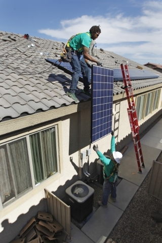 Guillermo Aviles hands a solar panel up to Solar City installation crew leader Greg Kates as they install solar panels on a North Las Vegas home Thursday, Oct. 30, 2014. (Sam Morris/Las Vegas Revi ...