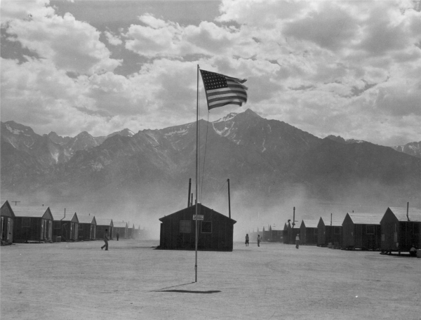 Scene of barrack homes at this War Relocation Authority Center at Manzanar, Calif. for evacuees of Japanese ancestry. A hot windstorm brings dust from the surrounding desert July 3, 1942. Photo by ...
