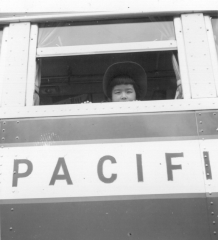 A girl looks out the window of a bus that transported Japanese Americans to wartime assembly centers in this photo taken in May 1942 in Hayward, California. DOROTHEA LANGE/JAPANESE AMERICAN RELOCA ...