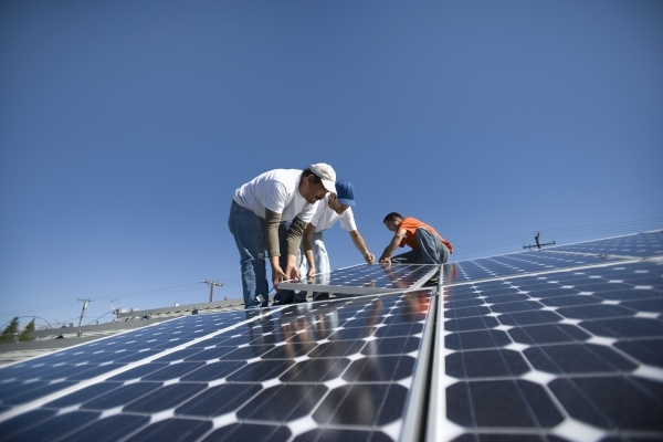 A group of men working on solar panels (Review-Journal File)