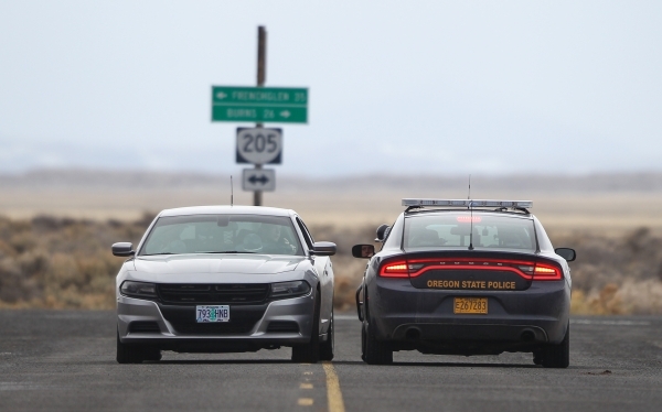 Oregon State Police officers confer near a roadblock near the Malheur National Wildlife Refuge headquarters, where four anti-government protesters remain, about 30 miles south of Burns, Ore., on F ...