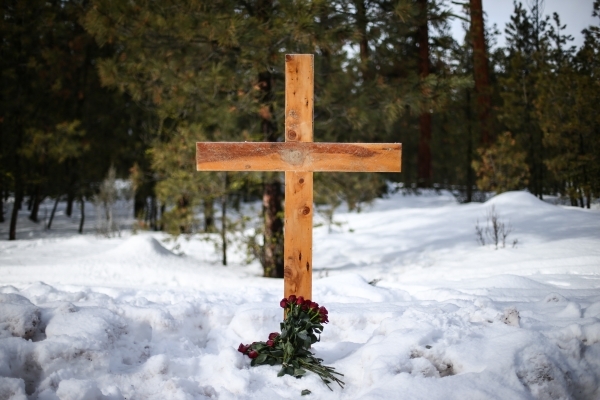 A cross and roses are shown where LaVoy Finicum was shot and killed Tuesday during an attempted arrest by law enforcement about 20 miles north of Burns, Ore. along U.S. Route 395, Friday, Jan. 29, ...