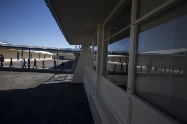 Children walk on school grounds at Lomie Heard Elementary School inside Nellis Air Force Base on Tuesday, Feb. 9, 2016, in Las Vegas. The school will close its doors at the end of the school year  ...