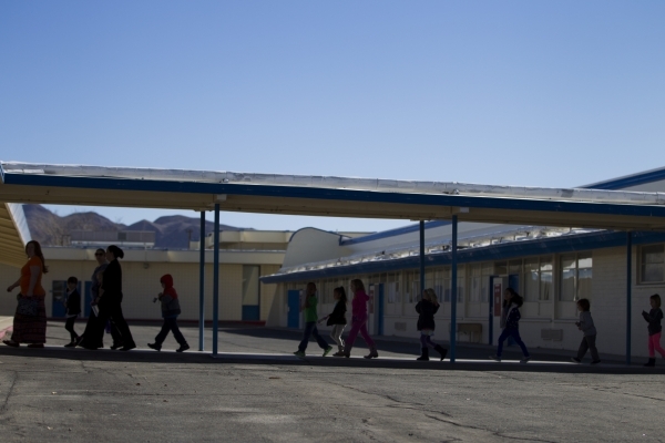 Children walk on school grounds at Lomie Heard Elementary School inside Nellis Air Force Base on Tuesday, Feb. 9, 2016, in Las Vegas. The school will close its doors at the end of the school year  ...