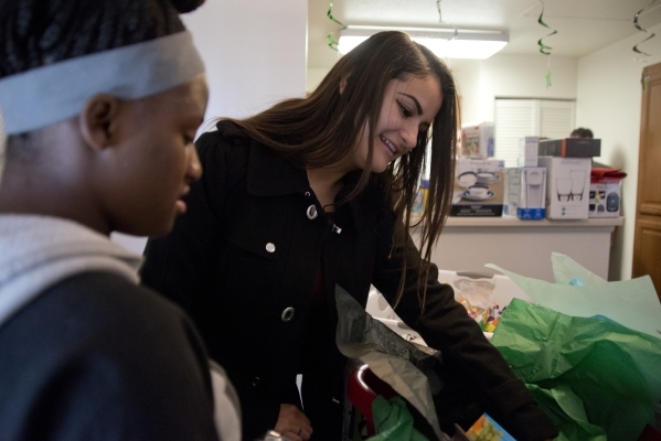 April Langstaff, left, and Banessa Gonzales open housewarming gifts inside their rent-free apartment during a welcome home party, part of Olive Crest‘s Project Independence program at Sahara ...