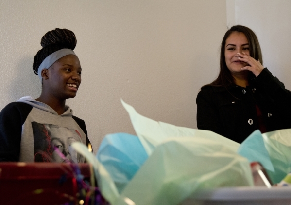 April Langstaff, left, and Banessa Gonzales open housewarming gifts inside their rent-free apartment during a welcome home party, part of Olive Crest‘s Project Independence program at Sahara ...