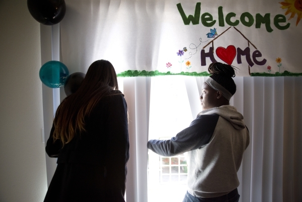 April Langstaff, right, and Banessa Gonzales walk through their rent-free apartment for the first time during a welcome home party, part of Olive Crest‘s Project Independence program at Saha ...
