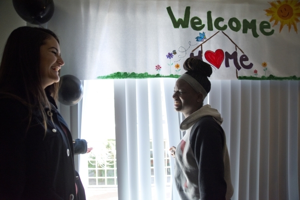 April Langstaff, right, and Banessa Gonzales walk through their rent-free apartment for the first time during a welcome home party, part of Olive Crest‘s Project Independence program at Saha ...
