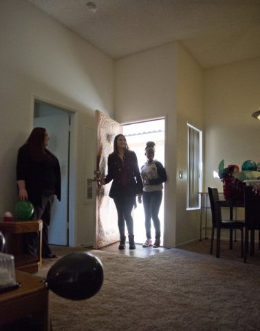 April Langstaff, right, and Banessa Gonzales enter their rent-free apartment  for the first time during a welcome home party, part of Olive Crest‘s Project Independence program at Sahara Wes ...