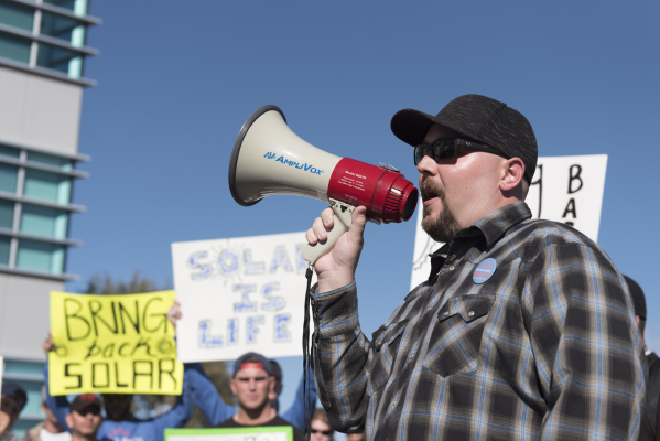 Bringingbacksolar.com volunteer Chandler Grey, right, speaks to solar workers and supporters protesting outside of the Public Utilities Commission office at 9075 W. Diablo Dr. in Las Vegas Monday, ...