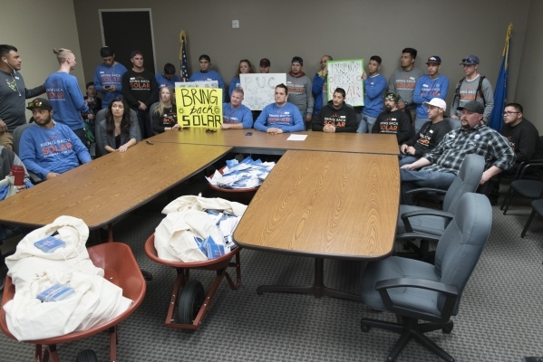 Solar workers and supporters gather inside the overflow room during a hearing bring with them three wheelbarrows filled with approximately 30,000 signatures of people who support restoring old roo ...