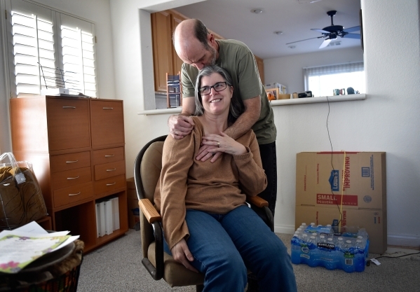 Larry Demetriades comforts his wife, Laura Demetriades, in the Henderson home of her father, Oliver Phillips, Tuesday, Feb. 9, 2016. Phillips, 85, died in January from injuries from a beating in h ...