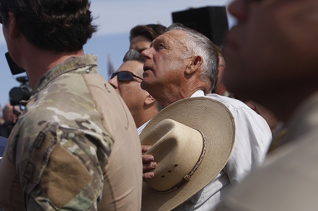 Rancher Cliven Bundy, center, sings the national anthem outside of Bunkerville while gathering with his supporters to challenge the BLM on April 12, 2014. (Jason Bean/Las Vegas Review-Journal)