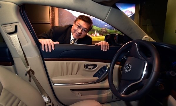 Michael Hu, president and CEO of 2050 Motors peers through the window of his Ibis prototype, an all electric and carbon fiber body automobile, at the William Carr Gallery at Tivoli Village Friday, ...