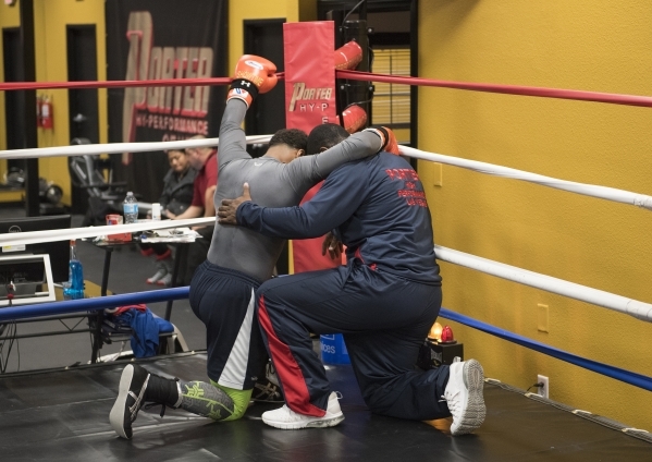 Professional boxer and former IBF welterweight champion "Showtime" Shawn Porter, left, is seen praying with his father, Ken Porter, before the start of training at his gym, the Porter Hy ...