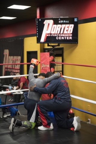 Professional boxer and former IBF welterweight champion "Showtime" Shawn Porter, left, is seen praying with his father, Ken Porter, before the start of training at his gym, the Porter Hy ...