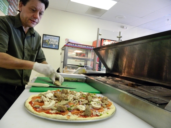 Owner Alfredo Calderon puts toppings on a pizza at Gators Pizza, 1639 W. Warm Springs Road. Cassandra Keenan/View