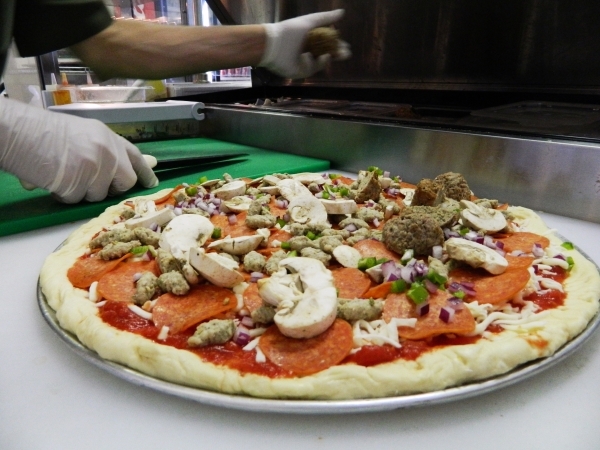 Owner Alfredo Calderon puts toppings on a pizza at Gators Pizza, 1639 W. Warm Springs Road. (Cassandra Keenan/View)