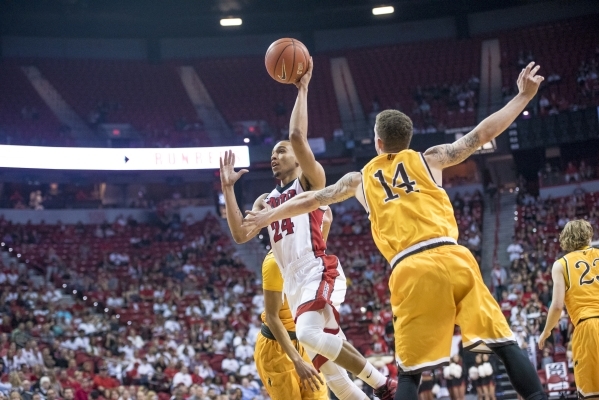 UNLV guard Jalen Poyser (24) takes the ball to the net while defended by Wyoming guard Josh Adams (14) during the first half at the Thomas & Mack Center in Las Vegas on Saturday, Feb. 27, 2016 ...