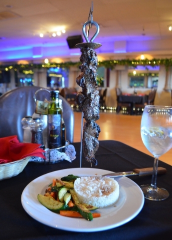 Beef espetadas are skewered on a metal rod, flame grilled and served dangling over a bed of rice and mixed vegetables at Vila Algarve Seafood & Grill. Ginger Meurer/Special to View