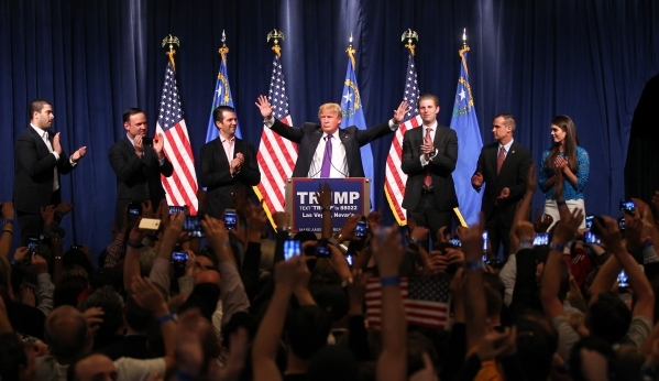 Republican presidential candidate Donald Trump, flanked by sons Donald Trump Jr., left, and Eric Trump, speaks at his watch party at Treasure Island hotel-casino in Las Vegas on Tuesday, Feb. 23,  ...