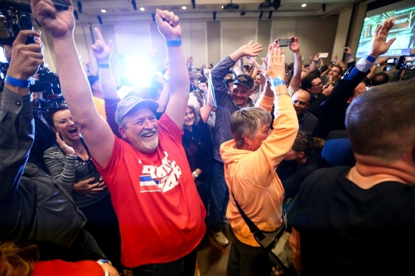 Bob Burns, left, celebrates with others as numbers come in projecting Republican presidential candidate Donald Trump as the winner of the Nevada GOP caucus at Trump‘s watch party at Treasure ...