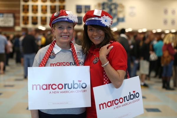 Janet Thietje, left, Stacie Weber don hats and signs in support of presidential candidate Marco Rubio during the 2016 Republican caucus at Centennial High School in Las Vegas on Tuesday, Feb. 23,  ...