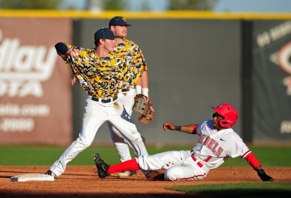 West Virginia second baseman Cole Austin attempts to turn a double play while UNLV base runner Keyon Allen slides into second base in the eighth inning of their NCAA college Baseball game at Earl  ...