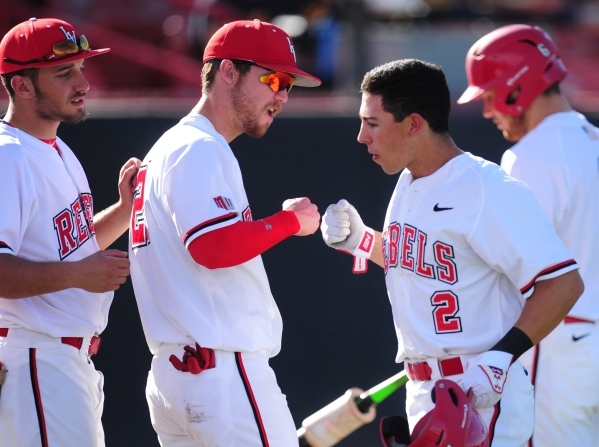 UNLV second baseman Justin Jones high fives teammates after hitting a solo home run against West Virginia in the fourth inning of their NCAA college Baseball game at Earl E. Wilson Stadium in Las  ...
