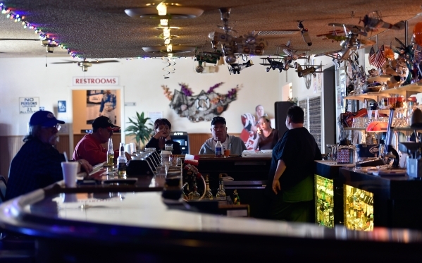 Bar patrons relax in the Cal-Nev-Ari casino Thursday, Feb. 25, 2016, in Cal-Nev-Ari. The casino decorated with an aviation themed decor currently features 17 slot and video poker games as well as  ...