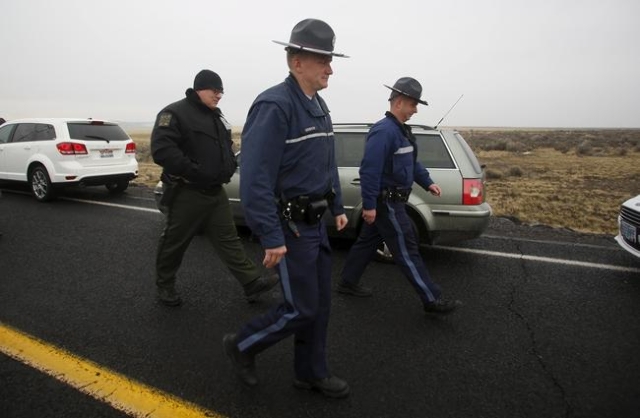 Law enforcement personnel walk along Highway 205, which is closed to most traffic, at the Malheur National Wildlife Refuge outside Burns, Oregon January 28, 2016. U.S. authorities tightened securi ...